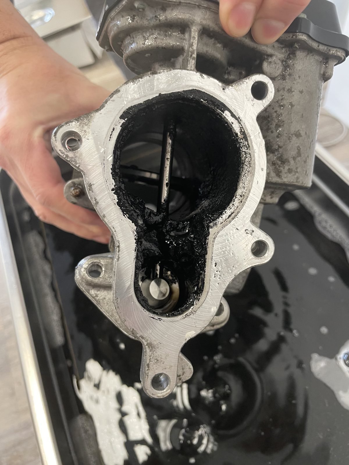 Limpieza de una pieza de motor en un limpiador ultrasónico